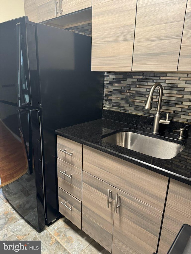 kitchen with sink, dark stone counters, and decorative backsplash