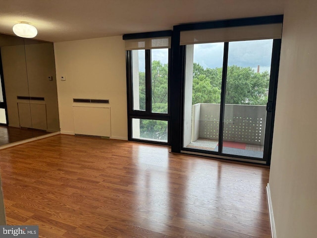 unfurnished room featuring radiator heating unit and hardwood / wood-style floors