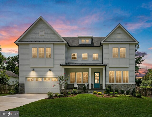 craftsman house with a garage, covered porch, and a lawn