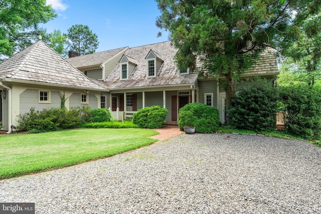 cape cod house with a front lawn