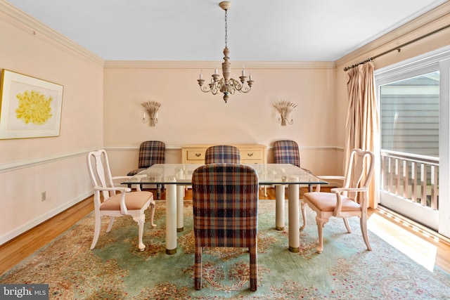 dining area featuring wood-type flooring, a chandelier, and ornamental molding