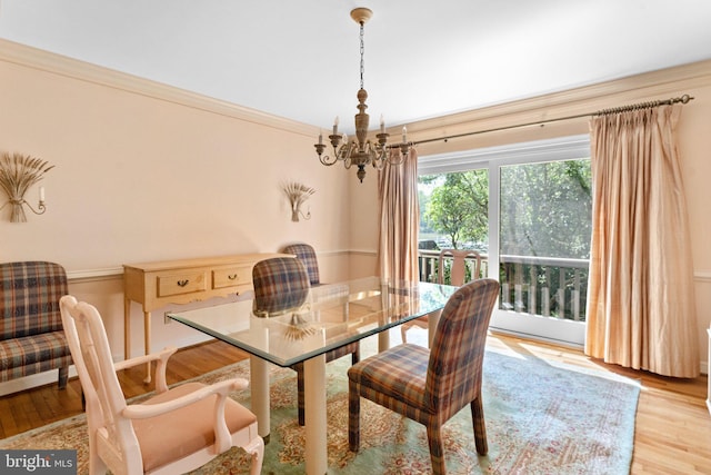 dining space featuring an inviting chandelier, crown molding, and light hardwood / wood-style flooring