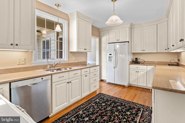 kitchen with hanging light fixtures, sink, white refrigerator with ice dispenser, dishwasher, and light hardwood / wood-style flooring