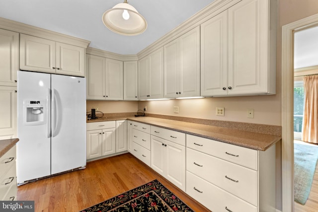 kitchen with light hardwood / wood-style flooring and white refrigerator with ice dispenser