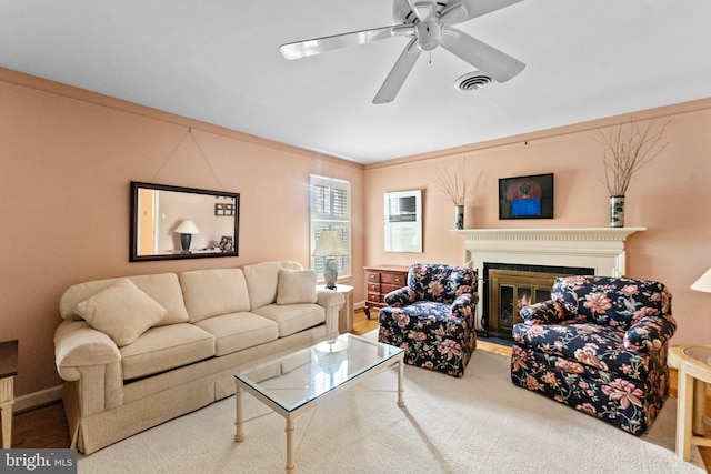 living room featuring hardwood / wood-style floors, ornamental molding, and ceiling fan