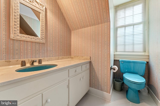 bathroom featuring tile patterned flooring, wooden walls, toilet, and vanity