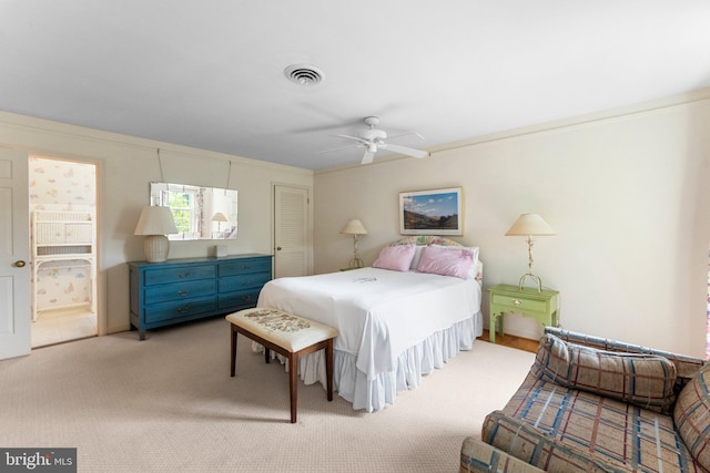 bedroom with light carpet, connected bathroom, and ceiling fan