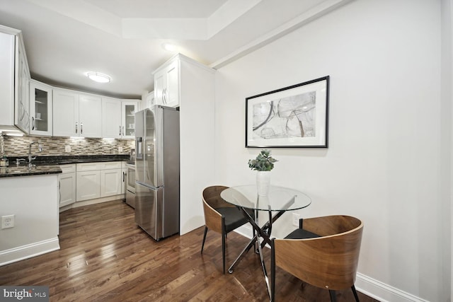 kitchen with white cabinetry, sink, decorative backsplash, stainless steel fridge with ice dispenser, and dark wood-type flooring