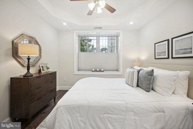 bedroom featuring ceiling fan, a tray ceiling, and hardwood / wood-style floors