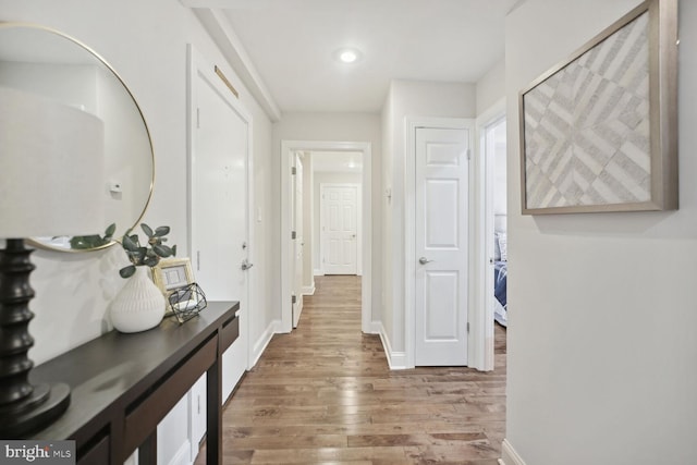 corridor with hardwood / wood-style flooring