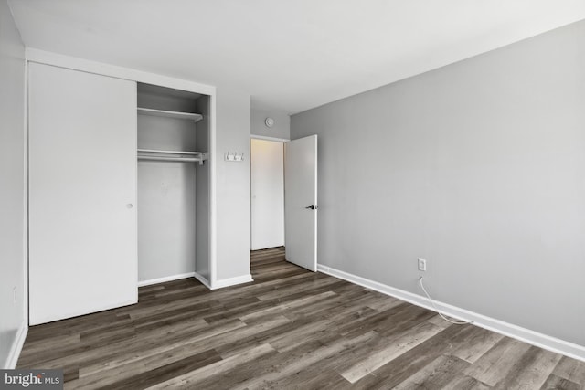 unfurnished bedroom with hardwood / wood-style flooring and a closet