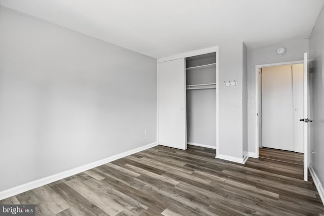 unfurnished bedroom featuring wood-type flooring and a closet