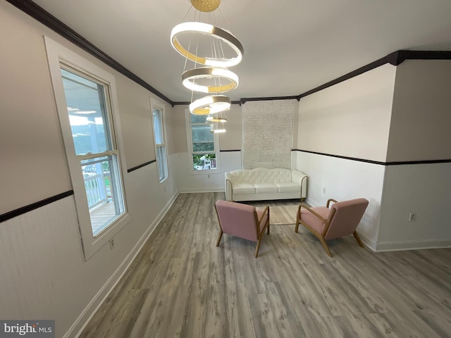 unfurnished room with crown molding, wood-type flooring, and an inviting chandelier