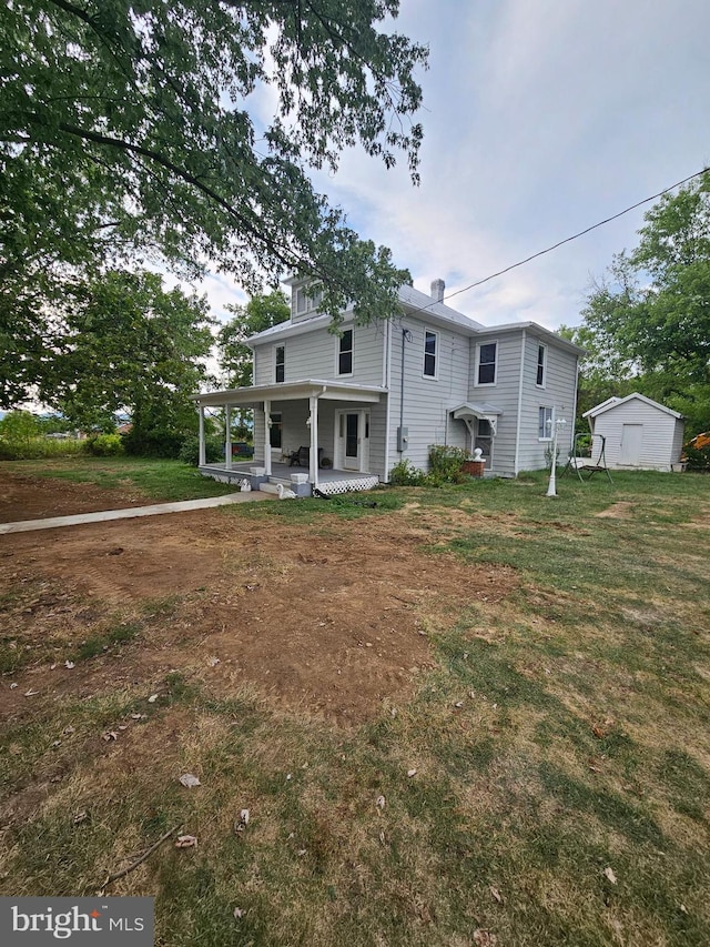 rear view of property featuring a porch and a yard