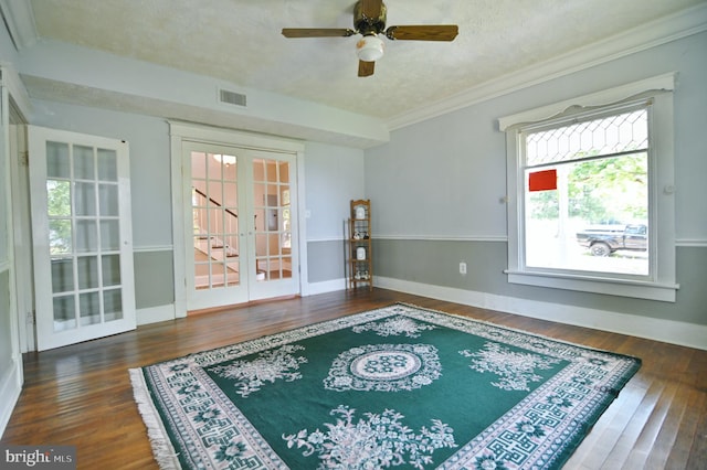 unfurnished room featuring crown molding, dark wood-type flooring, french doors, and a textured ceiling