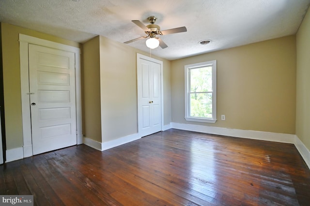 unfurnished bedroom with a closet, dark hardwood / wood-style floors, a textured ceiling, and ceiling fan