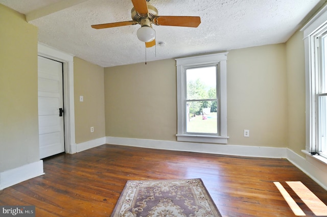 spare room with ceiling fan, a textured ceiling, and dark hardwood / wood-style flooring