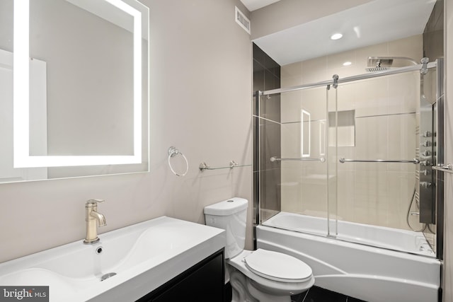 full bathroom featuring toilet, visible vents, combined bath / shower with glass door, and vanity