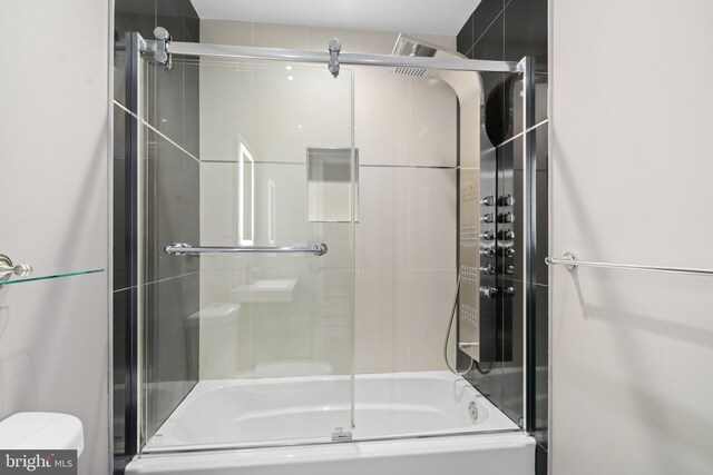 bathroom featuring bath / shower combo with glass door and toilet