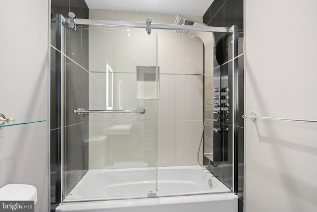 full bath featuring toilet and bath / shower combo with glass door