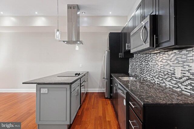 kitchen featuring hardwood / wood-style floors, sink, appliances with stainless steel finishes, island exhaust hood, and pendant lighting