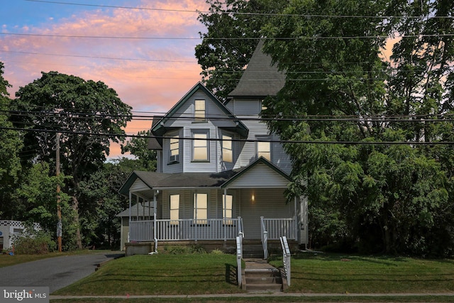 victorian house with a yard and covered porch