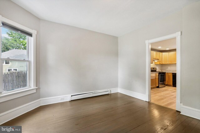 spare room with wood-type flooring and a baseboard radiator