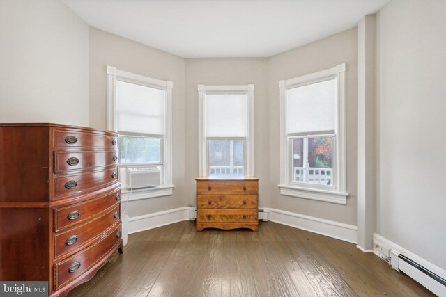 unfurnished room featuring dark hardwood / wood-style flooring and a baseboard radiator