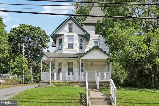 victorian-style house featuring covered porch and a front lawn