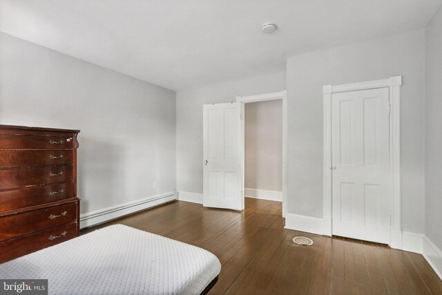 bedroom with a baseboard radiator and hardwood / wood-style floors