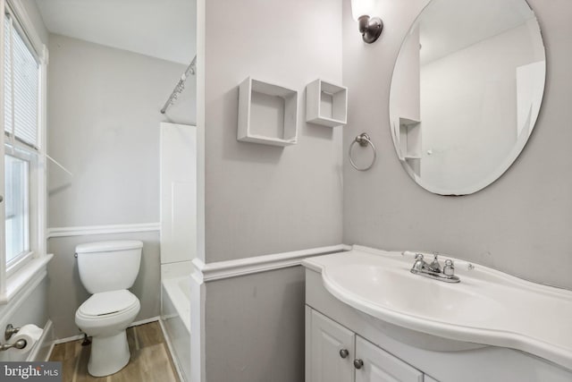 full bathroom featuring hardwood / wood-style floors, toilet, shower / bathtub combination, and vanity