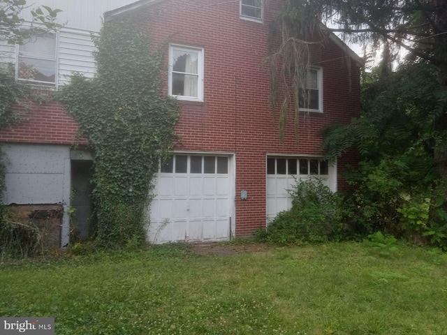 view of property exterior featuring a garage and a lawn