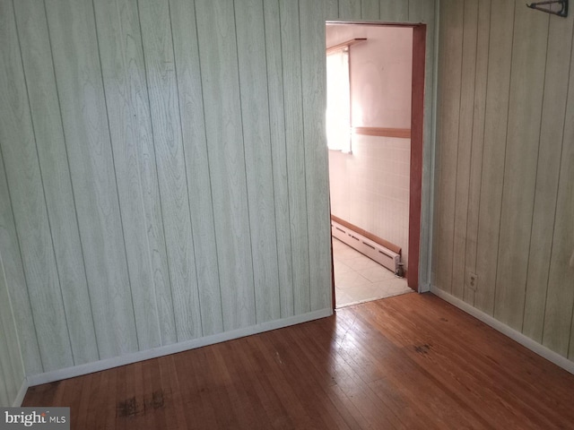 unfurnished room with light hardwood / wood-style floors and baseboard heating