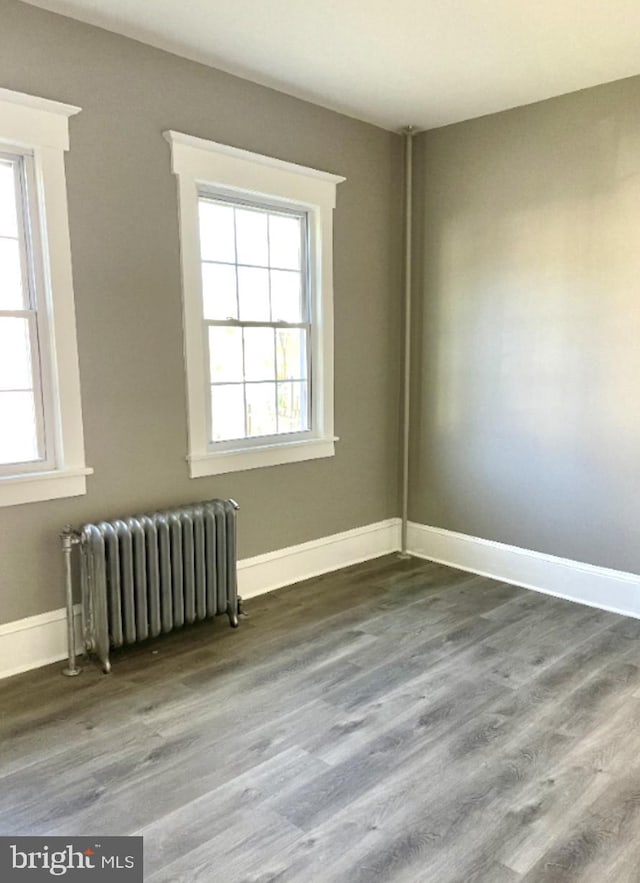 empty room featuring radiator and wood-type flooring