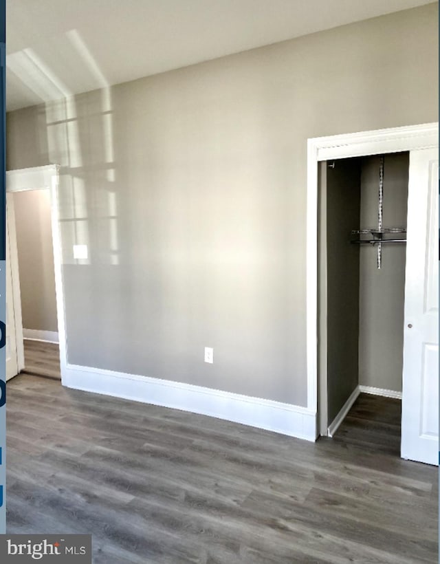 unfurnished bedroom with wood-type flooring and a closet