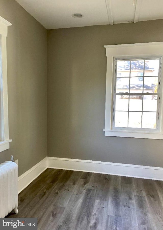 unfurnished room featuring dark hardwood / wood-style floors and radiator