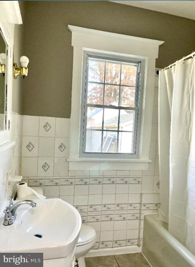 full bathroom with shower / tub combo with curtain, tile walls, toilet, and tile patterned flooring