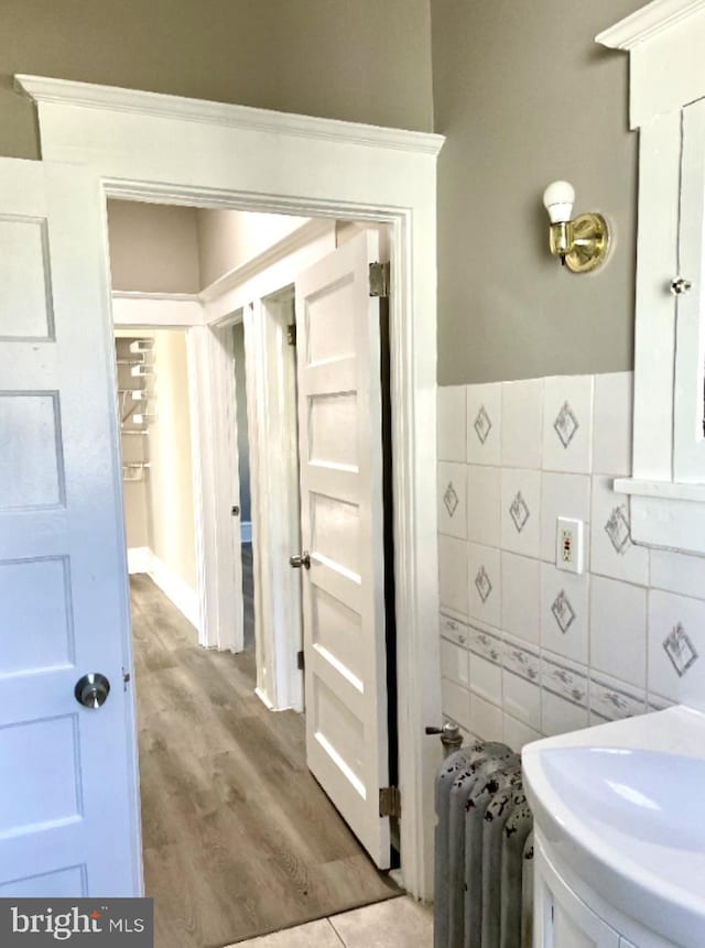 bathroom with radiator heating unit and hardwood / wood-style flooring