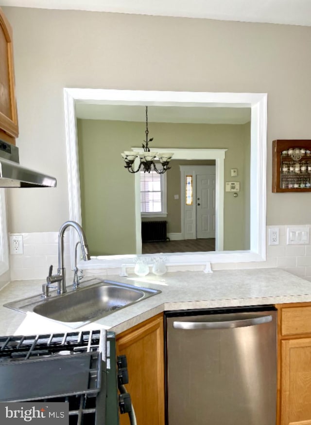 kitchen with decorative backsplash, a notable chandelier, dishwasher, hardwood / wood-style floors, and sink