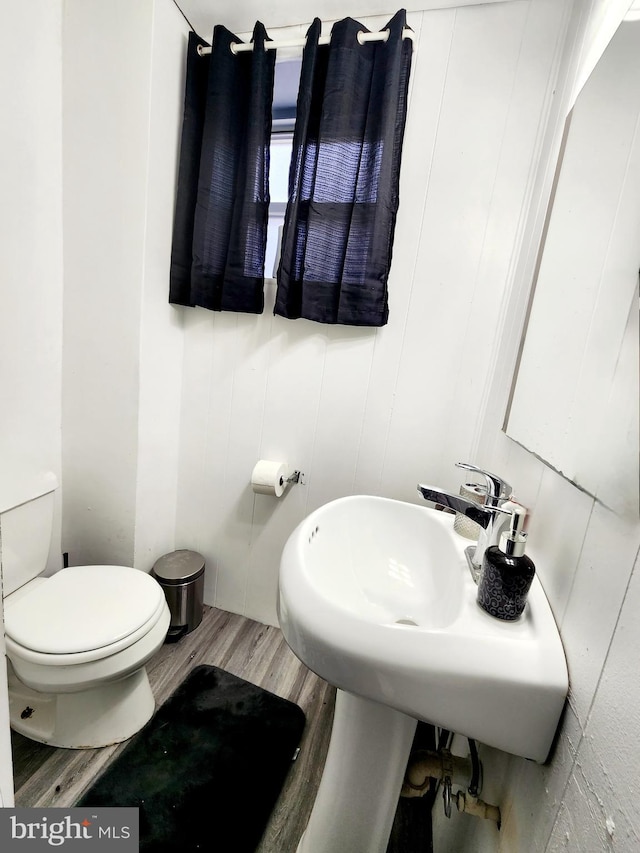 bathroom featuring hardwood / wood-style flooring and toilet