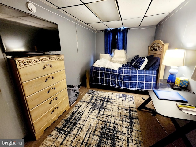 carpeted bedroom featuring a drop ceiling