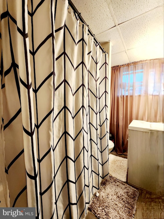 bathroom featuring a drop ceiling and toilet