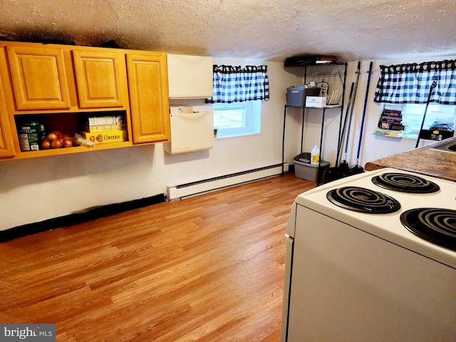 kitchen with light wood-type flooring, sink, stove, a baseboard radiator, and a textured ceiling