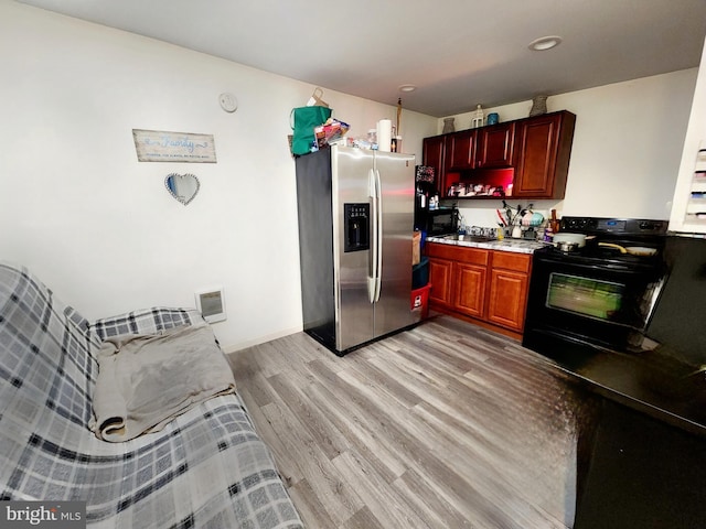 kitchen with light hardwood / wood-style floors, sink, black / electric stove, and stainless steel fridge with ice dispenser