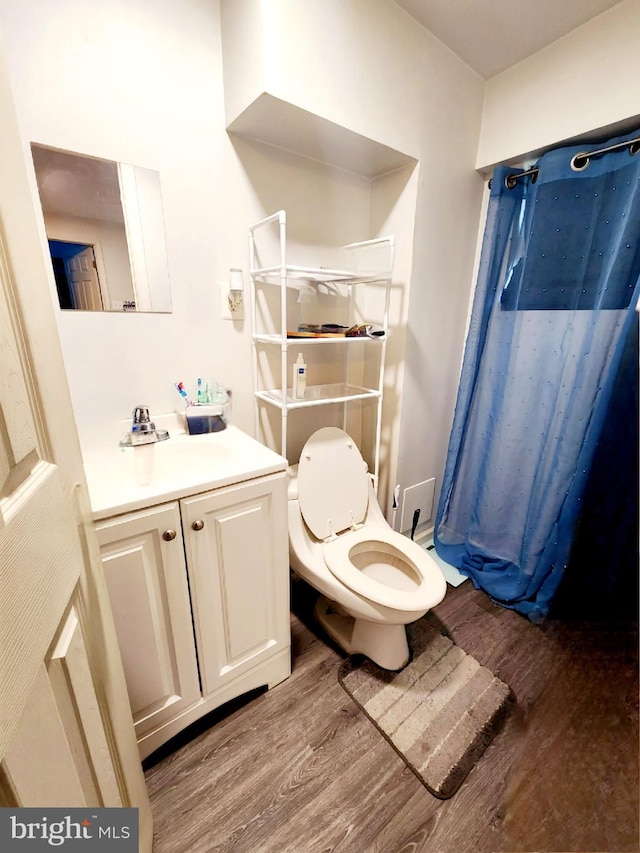 bathroom featuring vanity, toilet, and hardwood / wood-style flooring