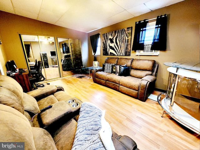 living room featuring light wood-type flooring, lofted ceiling, and a drop ceiling