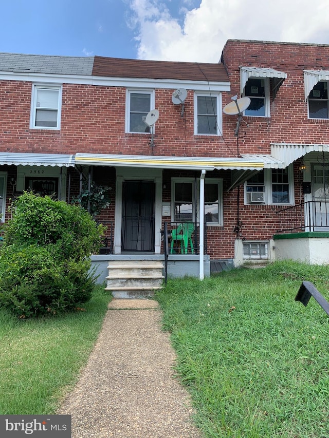 multi unit property featuring covered porch and a front lawn