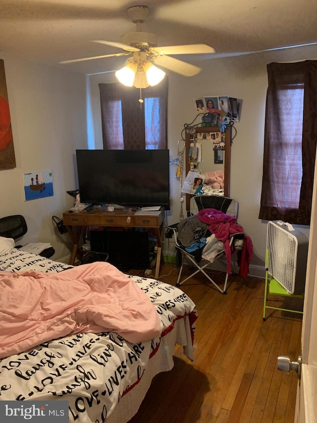 bedroom featuring hardwood / wood-style flooring, multiple windows, and ceiling fan