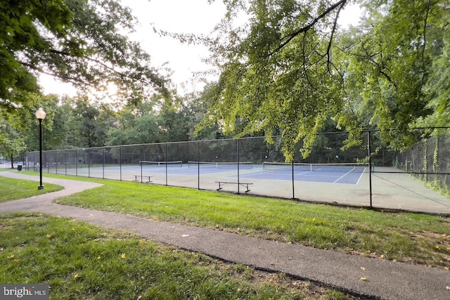 view of tennis court featuring a yard