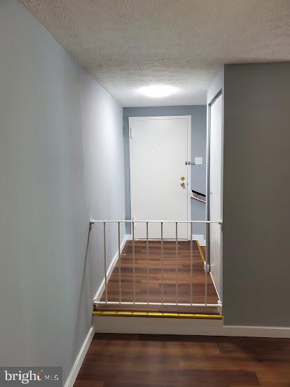 stairs with hardwood / wood-style floors and a textured ceiling